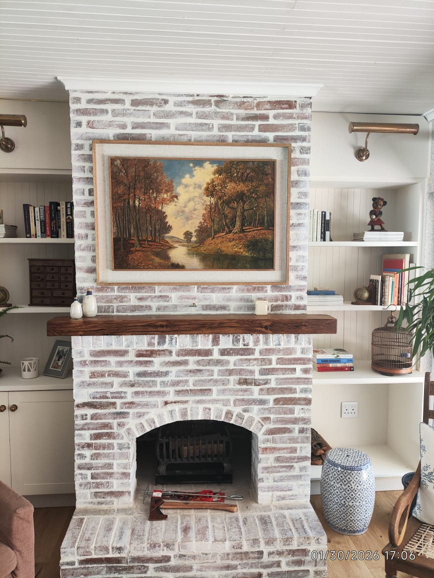 Built-in shelf installation surrounding a fireplace and professionally hung artwork in Cape Town